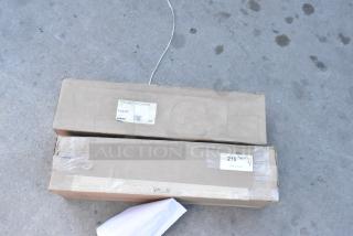 Two brand new Vollrath Lid Saver LS03IB-2B boxes marked VOL5T, showing minor scratches and dents.