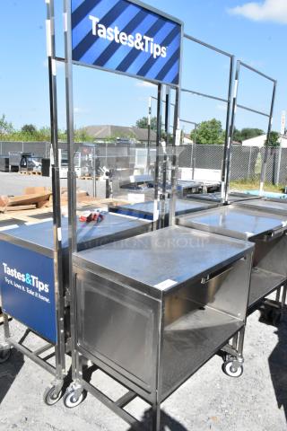Stainless steel cart with under shelf and commercial casters, featuring "Tastes&Tips" signage, in a used condition.