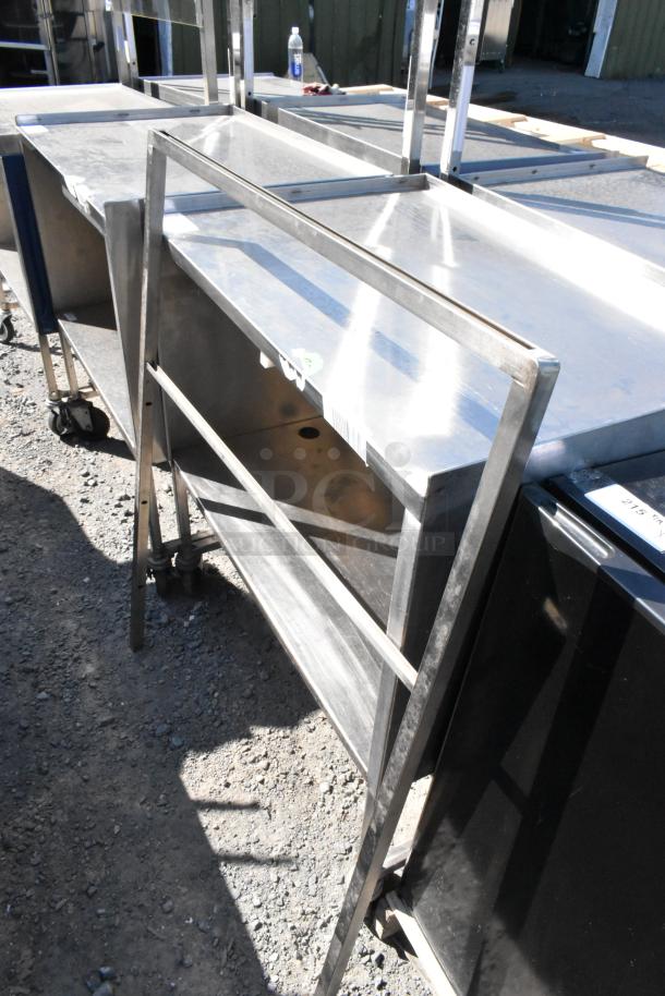 Stainless steel cart with under shelf and commercial casters. Features durable construction and mobility, suitable for commercial use.