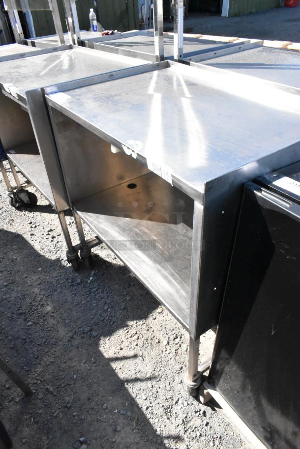 Stainless steel cart with under shelf on commercial casters, visible minor scuffs, sturdy construction, barcode tag affixed.