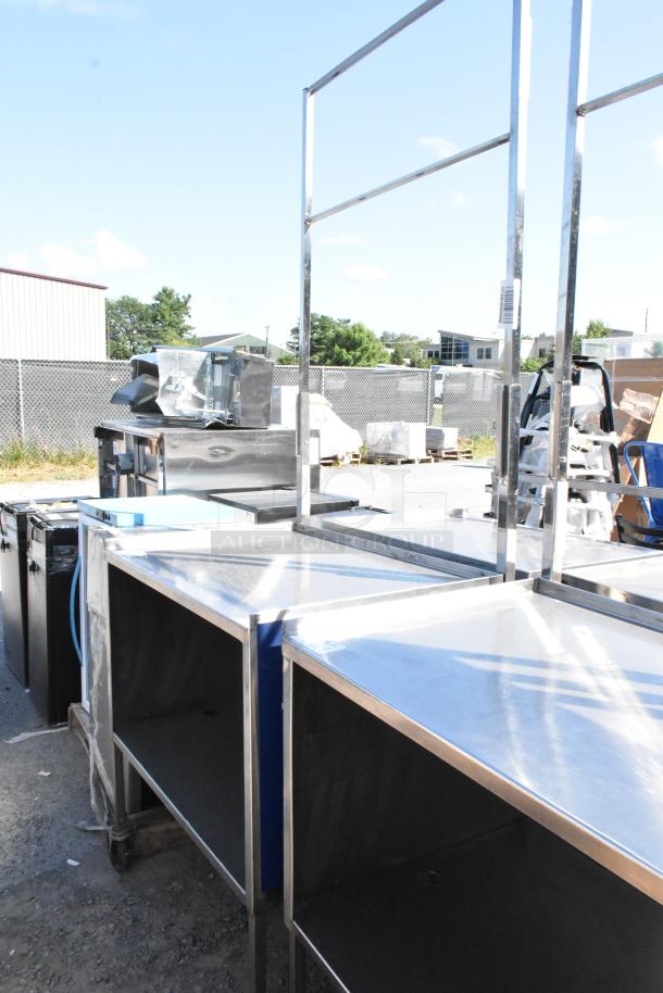 Stainless steel cart with under shelf on commercial casters, outdoor setting, excellent condition, ideal for storage or transport.