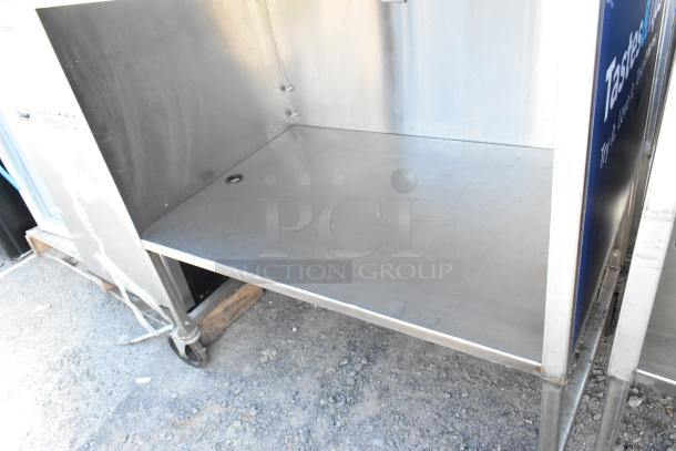 Stainless steel cart with under shelf, commercial casters, good condition, suitable for kitchen or industrial use.