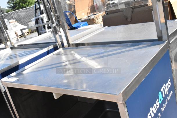 Stainless steel cart with under shelf, commercial casters, logo on side panel. Durable and functional for various uses.