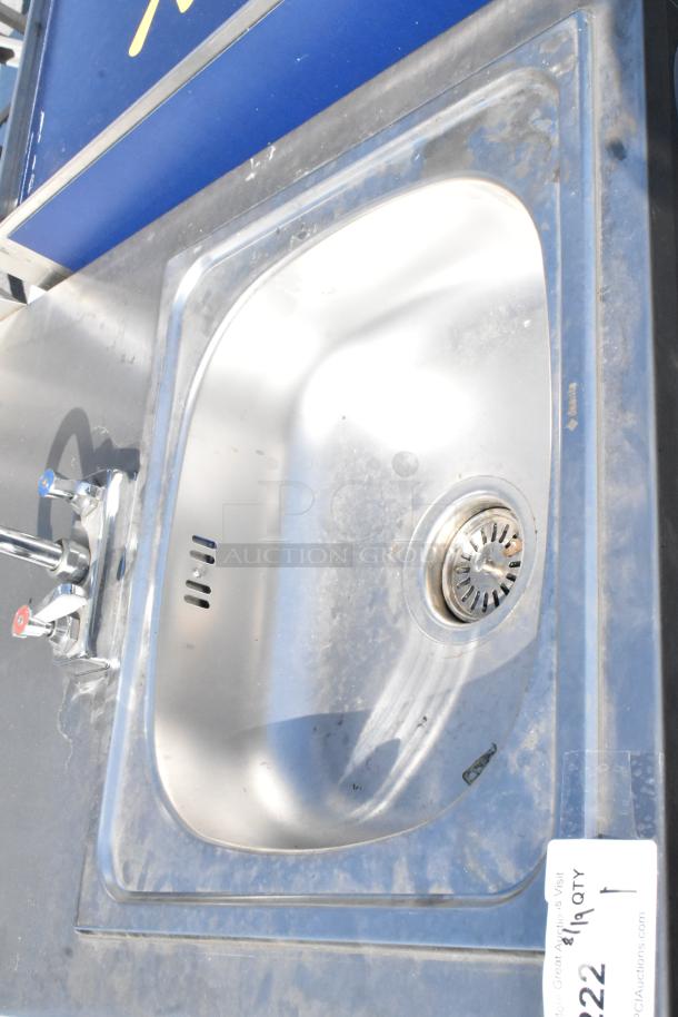 QualServ stainless steel portable single bay sink with faucets, commercial casters, and visible wear.