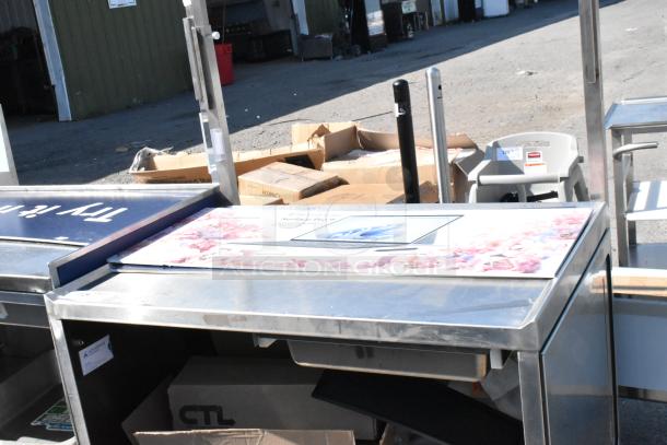 Stainless steel cart with under shelf on commercial casters, solid condition, suitable for industrial use.
