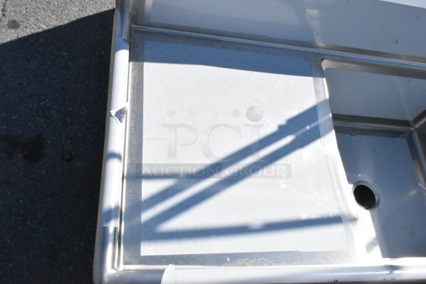 Brand new Regency 600S3242424S stainless steel sink, 124", 3 compartments, 2 drainboards, minor scratches visible.