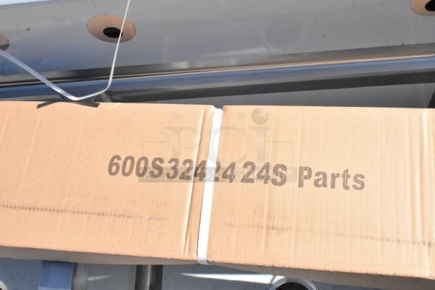 Cardboard box labeled "600S3242424S Parts," containing a Regency stainless steel commercial sink with three compartments and two drainboards.