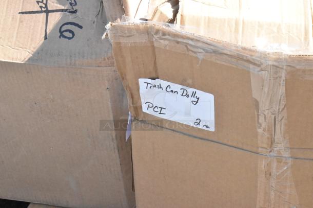 Cardboard boxes labeled "Trash Can Dolly, PCI, 2 ea" containing new scratch and dent items for auction.