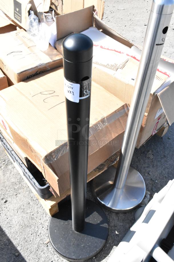 Two Smokers Outposts, one chrome, one black, shown standing on asphalt. "QTY 2X2" label visible on black post.