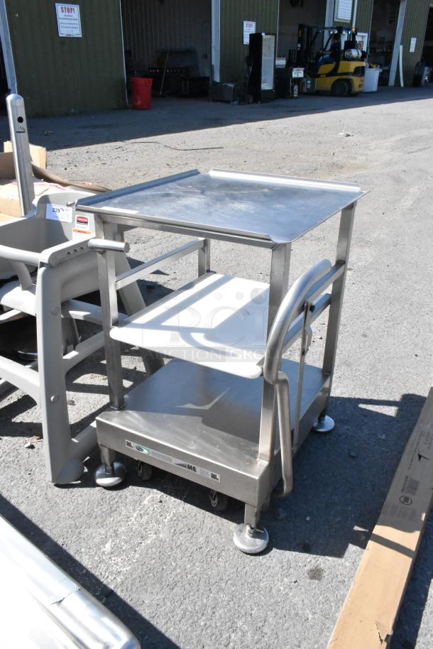 Stainless steel meat slicer equipment stand on commercial casters, with two shelves, and labeled "Face to Face."