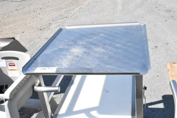 Face to Face stainless steel meat slicer stand with commercial casters. Light surface wear visible. Tag marked "230".