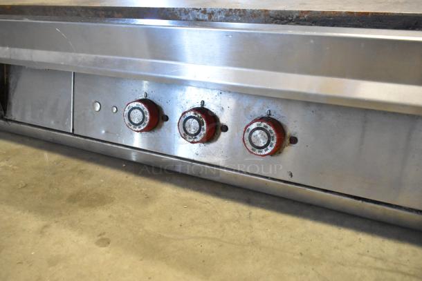 Stainless steel commercial countertop flat top griddle with thermostatic controls, shown with three control knobs, used condition.