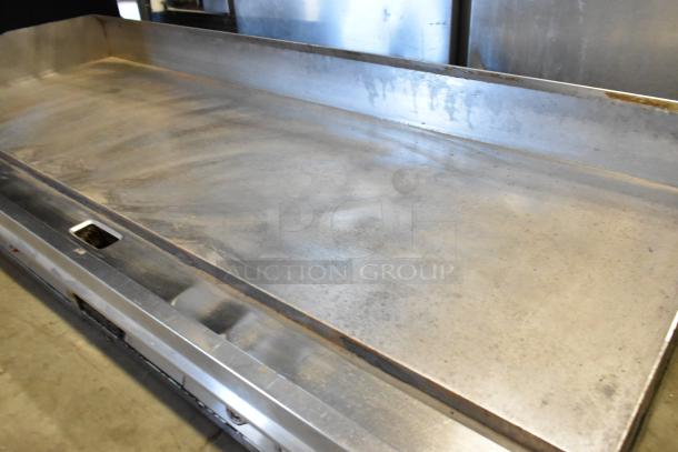 Stainless steel commercial countertop flat top griddle with thermostatic controls, in used condition.