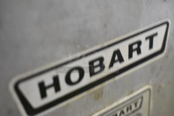 Hobart 1612E metal commercial meat slicer, featuring a blade sharpener, 120 volts, 1 phase; close-up of Hobart logo.