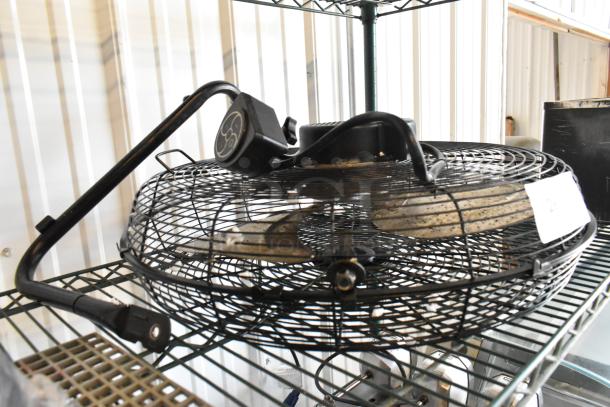 Lasko H20060 metal fan, 120 volts, 1 phase. Visible wear on casing, intact grille. Power cord attached. Suitable for industrial use.