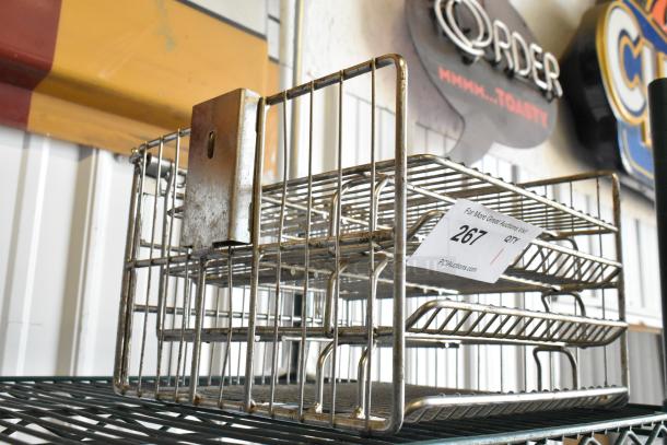Metal pressure fryer rack with wire design, visible wear, tag reading "267" from PCAuctions.com, industrial use.