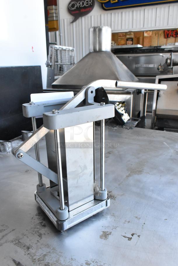 Metal countertop vegetable cutter with stainless steel body and lever mechanism. Light wear visible, suitable for commercial use.
