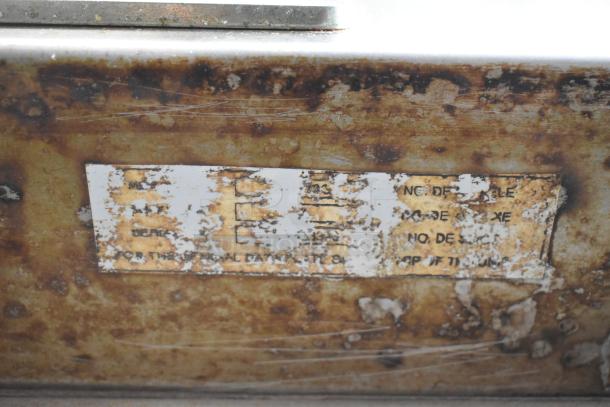 Baxter stainless steel commercial rack oven label, worn condition, showing partial serial and model information.