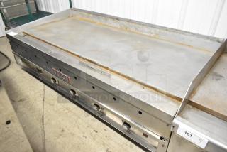 Vulcan stainless steel commercial countertop flat top griddle, featuring four control knobs. Some surface wear visible.