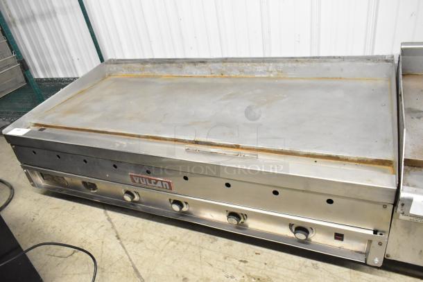 Vulcan stainless steel commercial countertop flat top griddle with four control knobs, showing minor wear.
