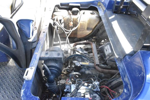Interior view of EZ Go 6-seat golf cart engine compartment, showing wiring and components, highlighting maintenance accessibility.
