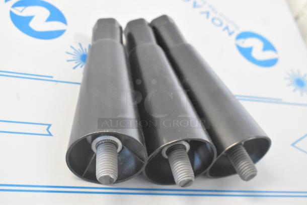 Close-up of black metal machine parts on a patterned background.