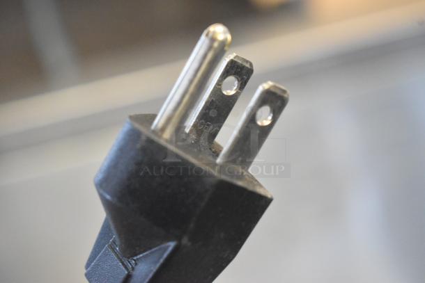Close-up of the power plug for a Vollrath RDE7148 stainless steel refrigerated display case, 120 volts.