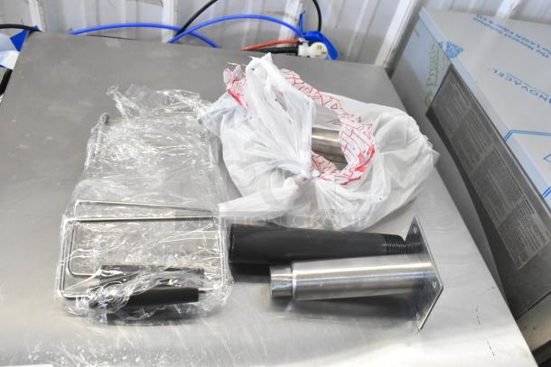 New Avantco 177FBF2624NG stainless steel funnel cake/ donut fryer accessories. Wrapped components on stainless steel surface.