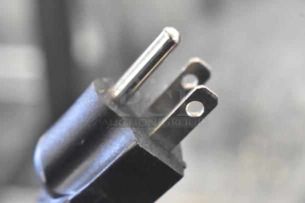 Close-up of a power cord plug, compatible with the 2024 Avantco 177HDC13 heated display case, 120 volts.