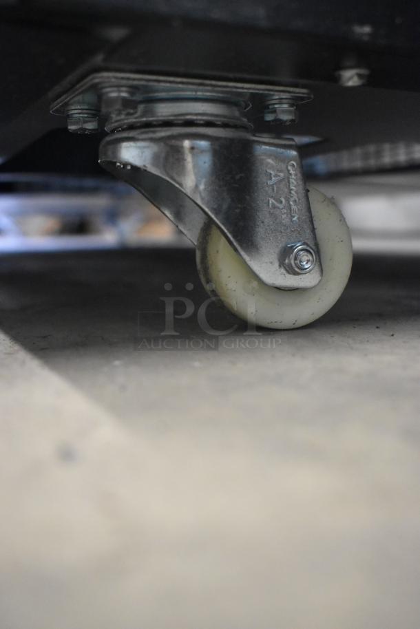Close-up of a caster wheel on an Avantco 193BCTD72B bakery display case. Metal and rubber components detailed.