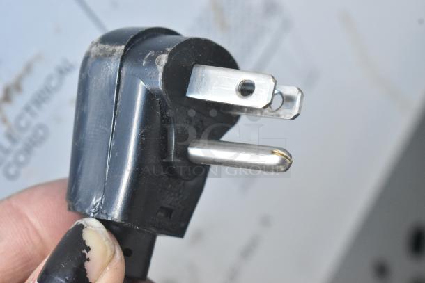 Close-up of a three-prong power plug for a Scotsman CU0715MA-1A ice machine, showing slight wear.