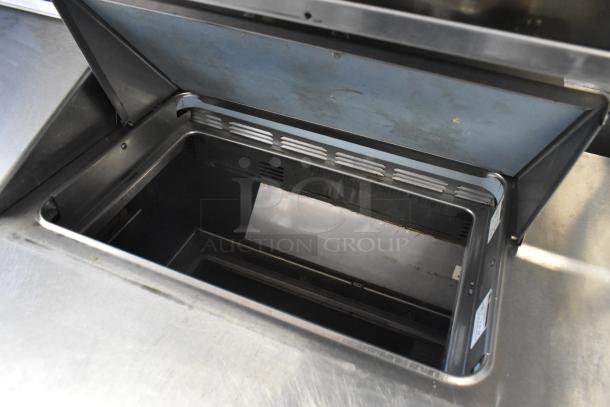 Delfield stainless steel sandwich salad prep table with an open lid showing stainless interior. Features 4 drawers, over shelf, 115 volts.