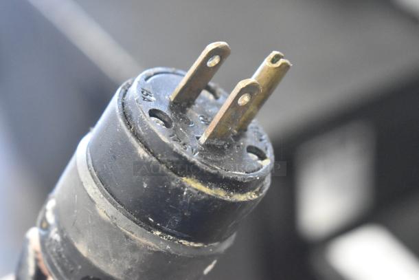 Close-up of a power plug for a 2018 Doyon CPF412 bread loaf slicer, showing prongs and wear.