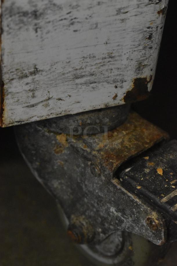 2018 Doyon CPF412 bread loaf slicer base, close-up of rusted metal caster, showing signs of wear.
