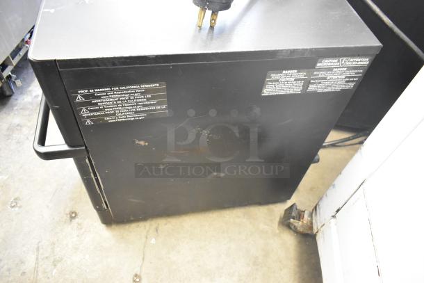 Turbochef metal commercial countertop electric oven, 208/240 volts, 1 phase. Black exterior with visible wear and warning labels.