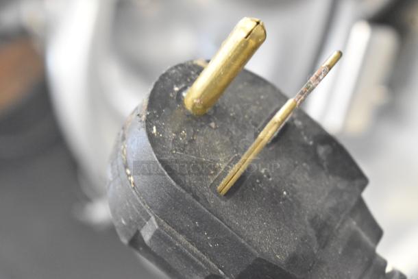 The image shows a close-up of an electrical plug for a Turbochef Rapid Cook Oven, featuring two prongs and visible wear.