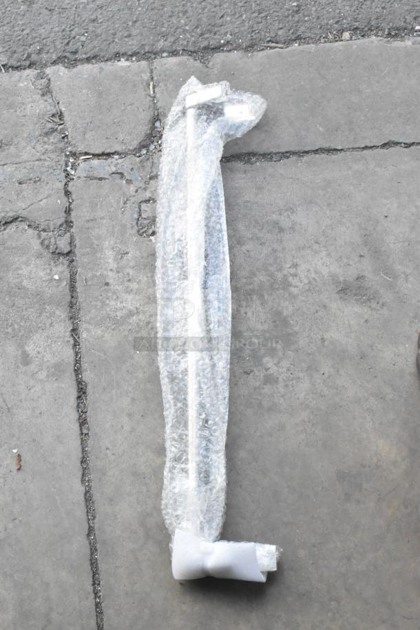 Bubble-wrapped item on concrete, possibly a component for an appliance or furniture, condition unclear.