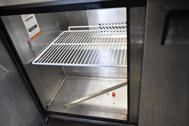2019 Bison BST-72-30 stainless steel prep table interior with wire shelf and visible label, indicating model and brand.
