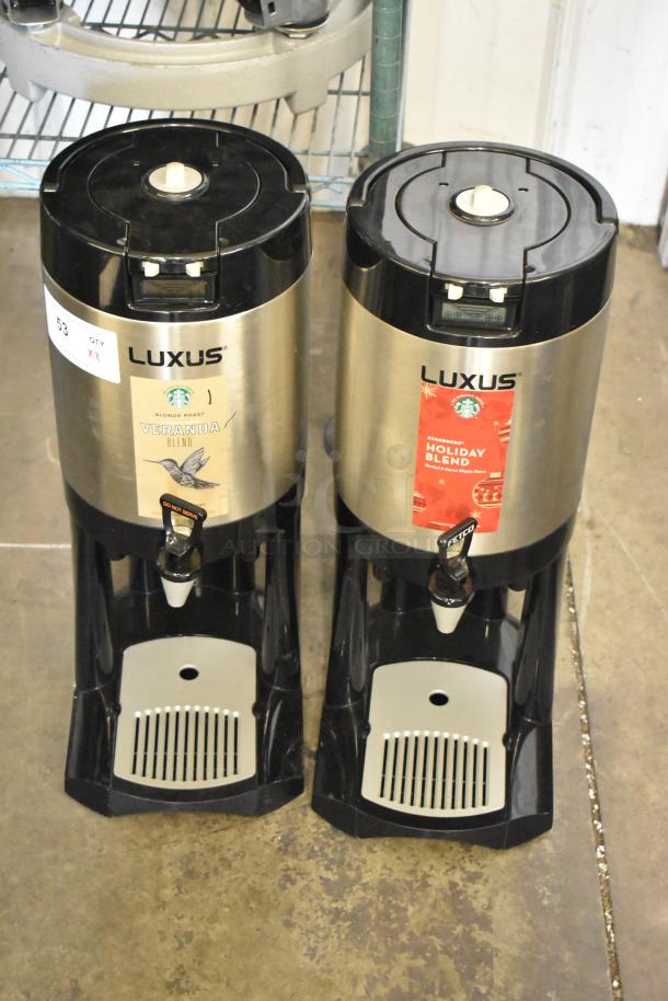 Two Fetco Luxus L3D-15 stainless steel beverage dispensers with drip trays, labeled Veranda and Holiday Blend.