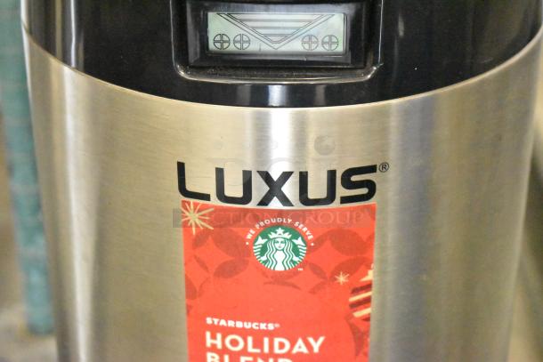 2 Fetco Luxus L3D-15 stainless steel beverage dispensers with digital display and drip tray, featuring Starbucks Holiday Blend label.