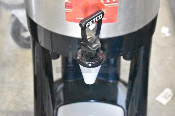 Fetco Luxus L3D-15 stainless steel beverage dispenser with drip tray, features durable construction and easy-pour spout.