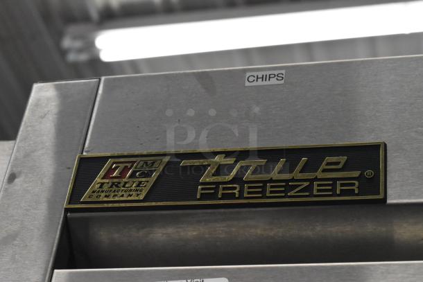 True T-72F stainless steel commercial freezer, featuring three doors, poly coated racks, and commercial casters.
