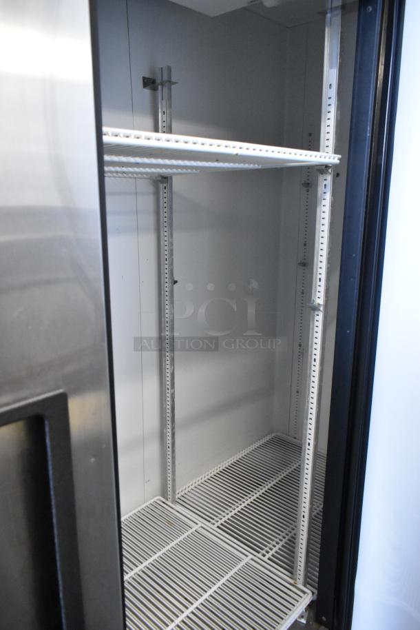 True T-72 stainless steel 3-door reach-in cooler interior with poly-coated racks, on casters, 115V, 1-phase.