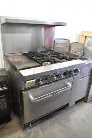 Cookrite stainless steel 4-burner range with griddle, oven, over shelf, and back splash on casters. Includes visible wear.