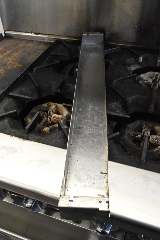 Cookrite stainless steel commercial gas range, four burners, flat top griddle, oven, overshelf, backsplash, on casters. Usage wear.