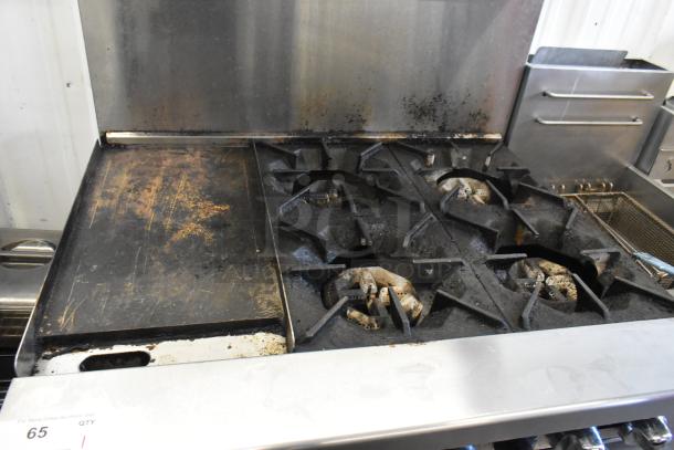 Cookrite stainless steel 4-burner gas range with flat top griddle, oven, over shelf, backsplash, and casters. Used condition.