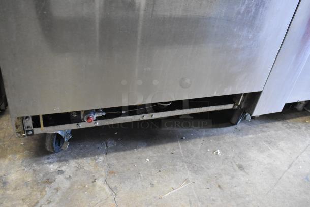 Cookrite stainless steel commercial gas range with 4 burners, flat top griddle, oven, over shelf, backsplash, and casters.