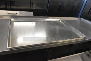 Full-size metal baking pan, slightly used, on a stainless steel surface. Auction includes 24 pans.