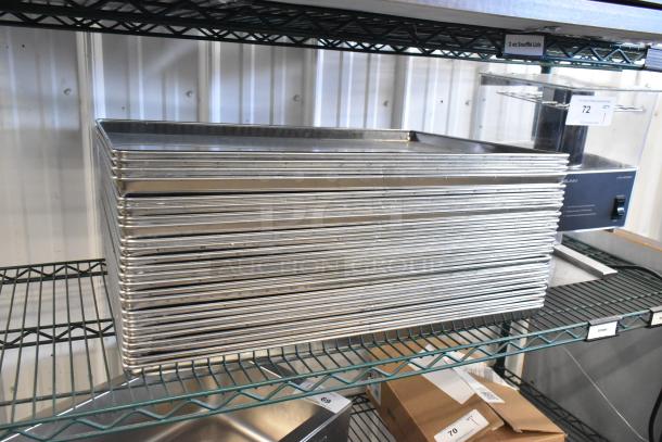 Stack of 24 metal full-size baking pans on wire shelf, showing polished finish, ideal for commercial baking.