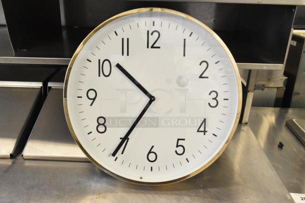 Large wall clock with a white face, black numerals, and gold trim. Additional framed pictures not shown. Auction lot of 7 items.